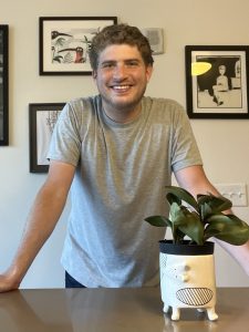 picture of Tanner with a plant on desk